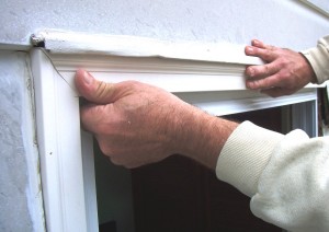 Slip the upper section behind the flashing at the top of the window