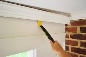 Slide a couple of wood shims between the molding and wall
